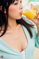 A woman drinking a glass of orange juice.