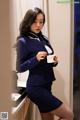 A woman in a blue suit holding a cup of coffee.