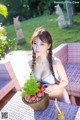 A woman sitting at a table with a bowl of fruit.